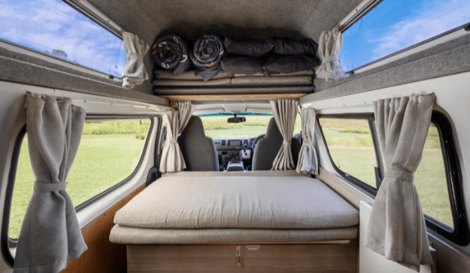 Het opgemaakte bed in de Endeauvour camper van Cheapa Campa